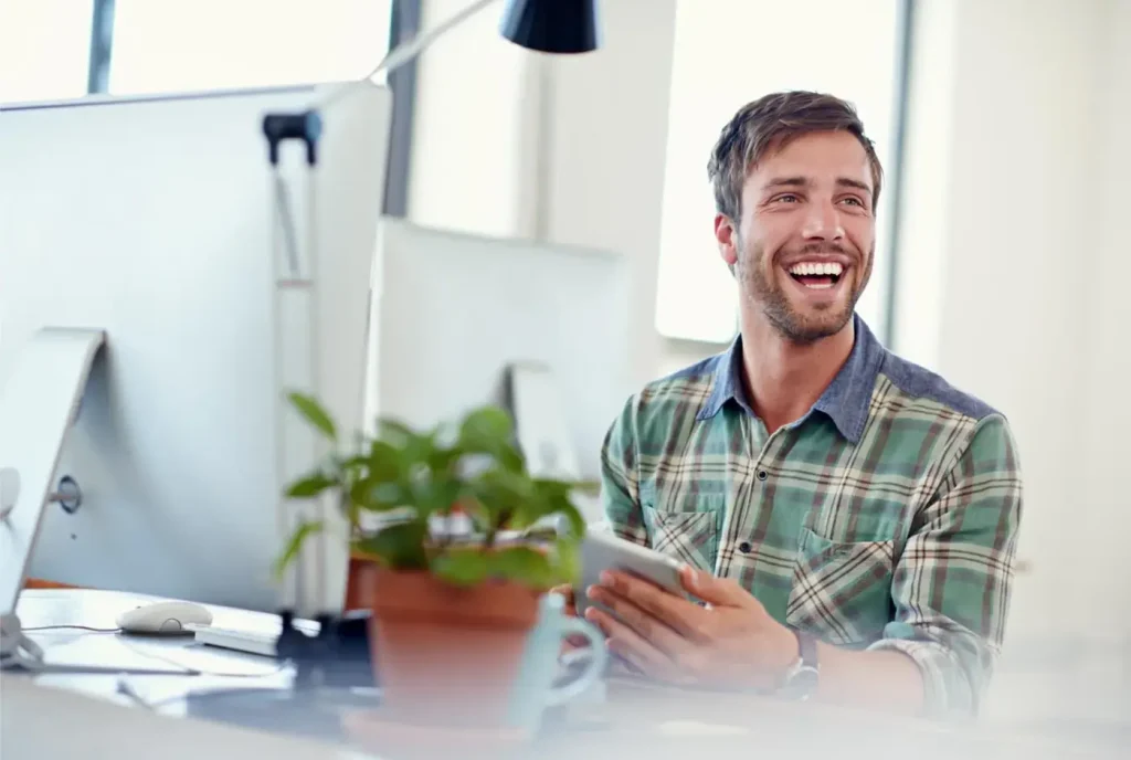 A professional smiling while learning on a laptop